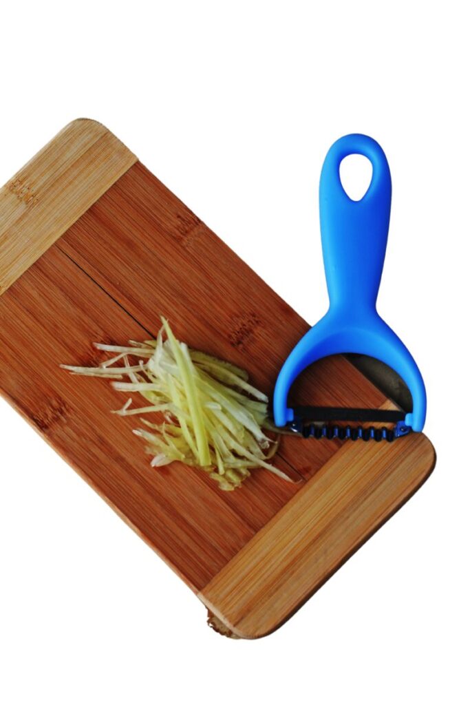 A large piece of carrots lies on a grater. Interrupted shredding