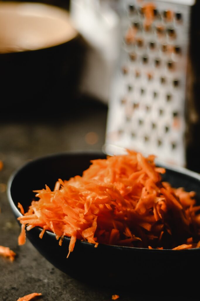 Premium Photo  Shredding grater and shredded carrots on a cutting