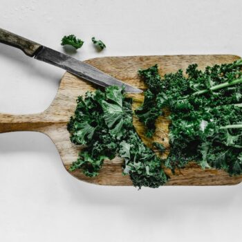 close up shot of chopped kale on a wooden chopping board