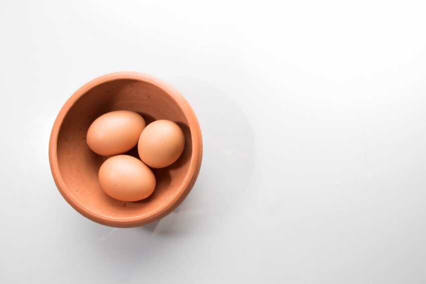 three brown eggs in bowl