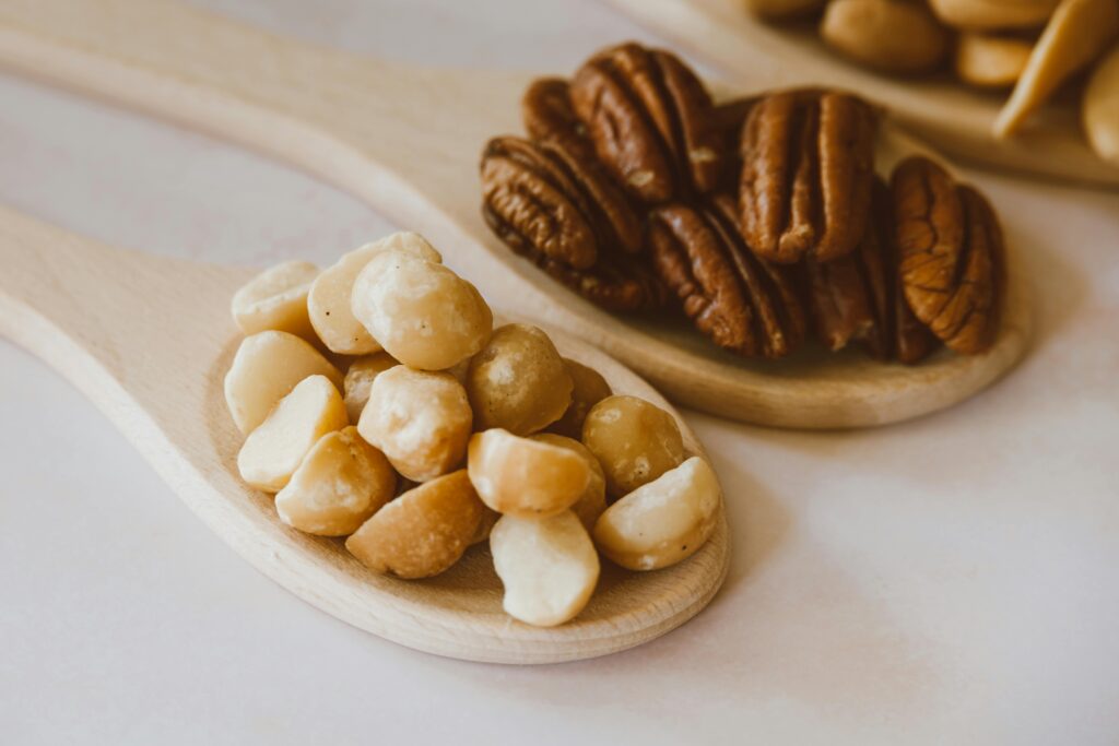 Detailed photograph showcasing a variety of nuts placed on wooden spoons, emphasizing texture and natural tones.