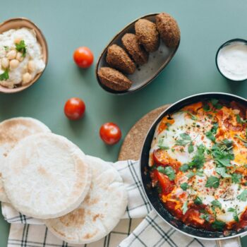 shakshouka falafel hummus and pita breads on the table