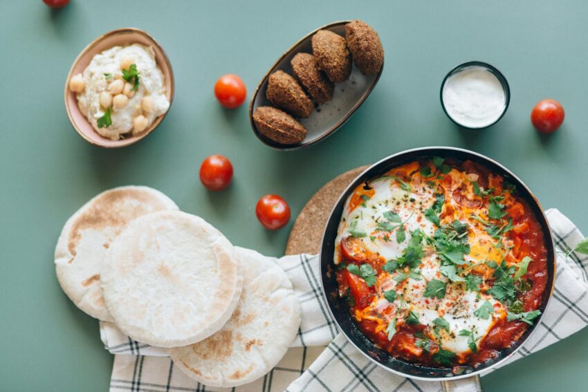 shakshouka falafel hummus and pita breads on the table