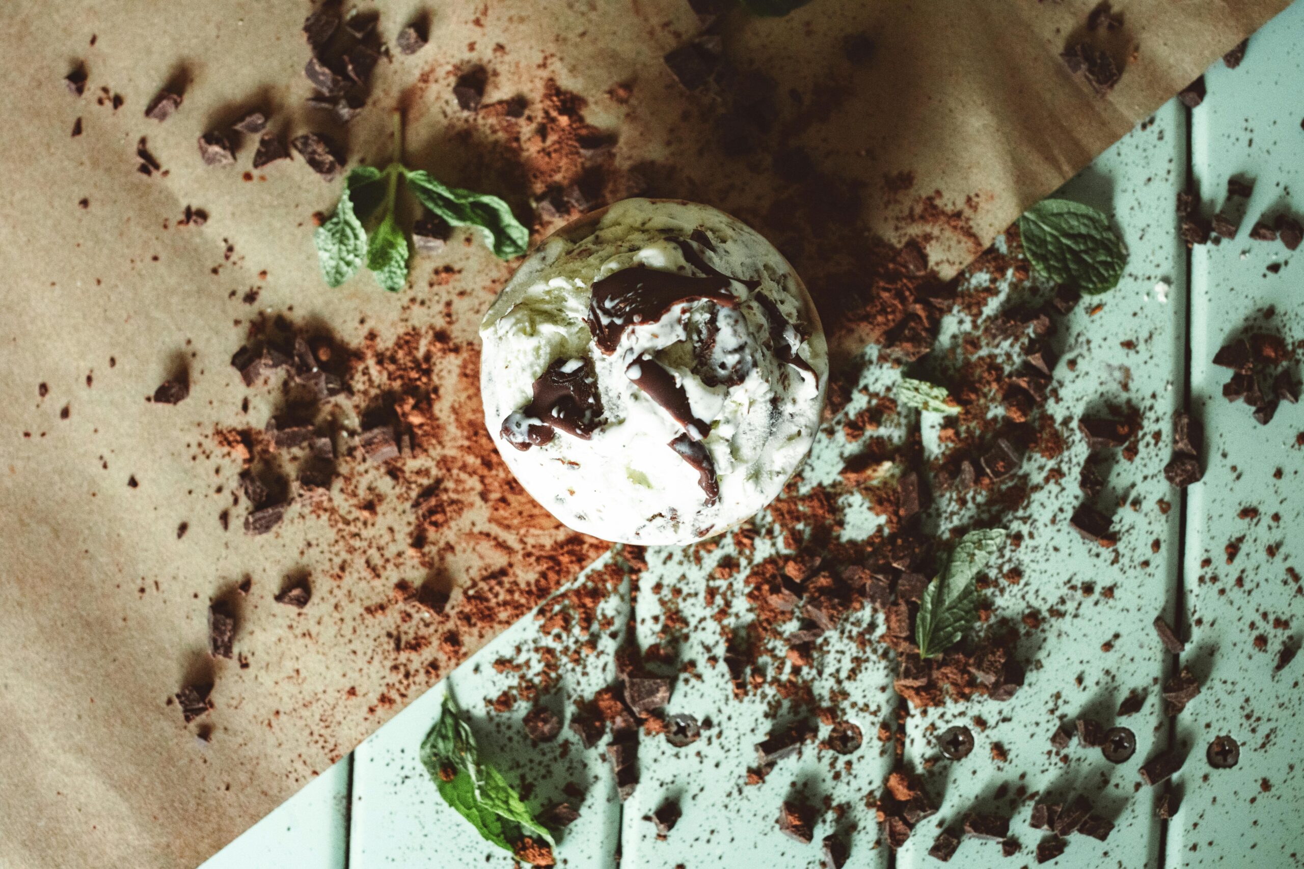 Top view of mint chocolate ice cream with cocoa and mint leaves.