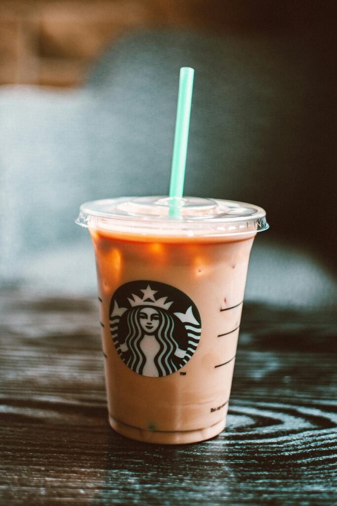 Chilled iced coffee in a Starbucks cup on a wooden table creating a refreshing vibe.